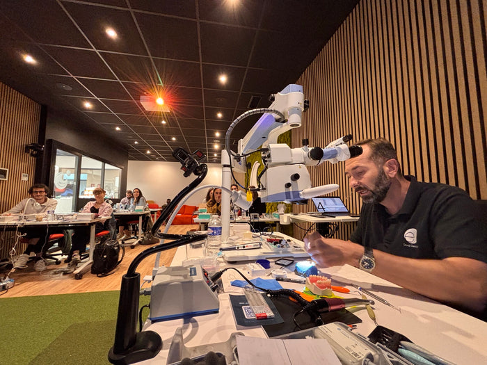 Démonstration live sous microscope opératoire retransmise à l'écran pour les participants